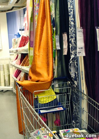 Clara playfully searching for curtains at IKEA, enjoying the shopping experience