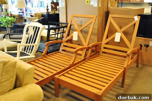 Two elegant wooden outdoor lounge chairs.