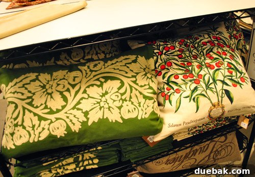 Holiday-themed pillow covers, one with red berries and a green lumbar pillow.