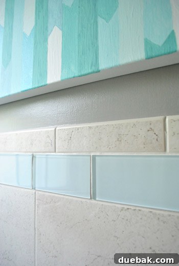 Close-up of the new 'snow white' clear glass border tiles, appearing blue-green due to reflections but adding a fresh look.