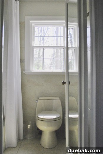 Another 'before' photo of the master bathroom, highlighting a cramped layout and outdated fixtures.