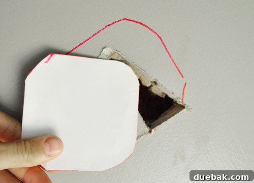 Tracing the template onto the ceiling with a red Sharpie for clear visibility