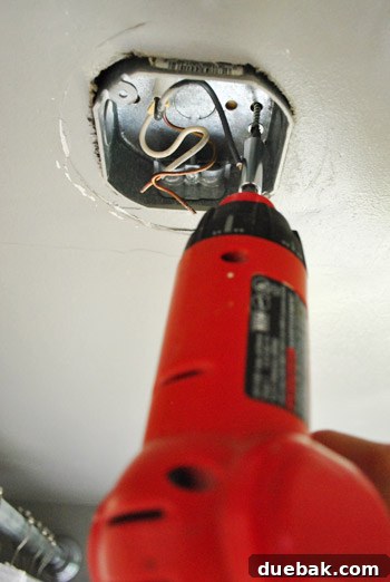 Removing screws from the old electrical box in the ceiling
