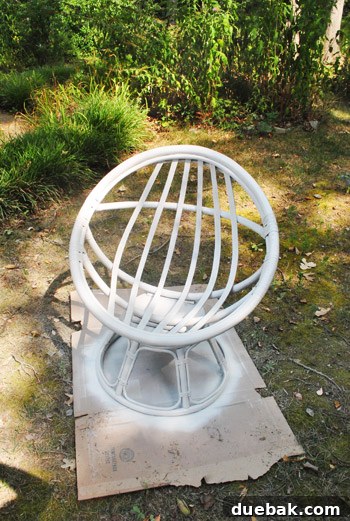 The egg chair after being painted white with a satin finish, looking elegant and revitalized.