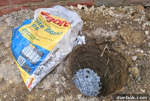 Deck post hole with a base layer of drainage gravel