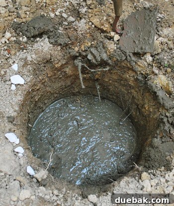 Freshly poured, self-leveled concrete footing in a deck hole