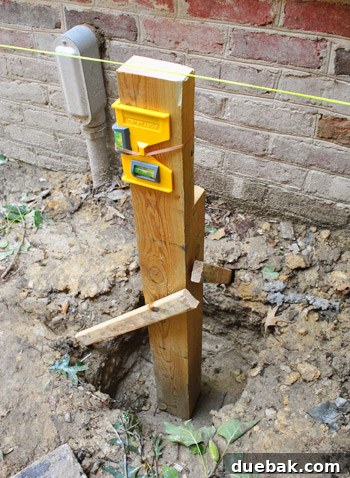 Deck post held plumb with temporary wooden stakes in a concrete hole