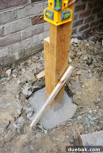 Dry Quikrete no-mix concrete being poured around a deck post