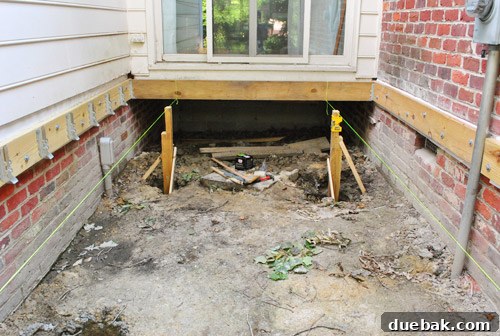 Two deck posts set in concrete, with string guides still attached