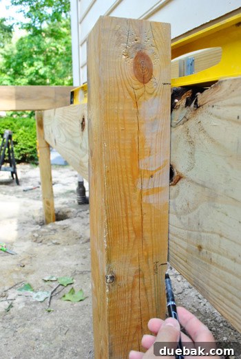 Middle deck post being marked for notching, with the girder already in place
