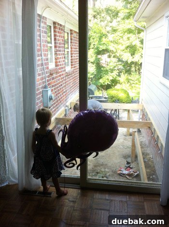 Clara and her octopus balloon watching deck construction