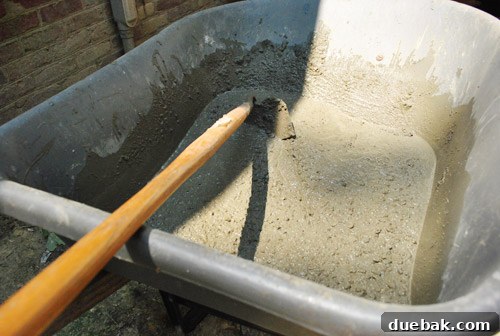 Closer view of concrete being mixed in a wheelbarrow