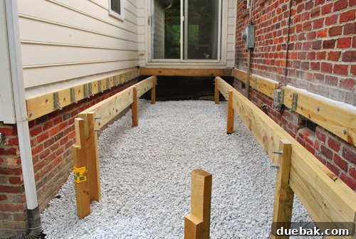 The completed gravel layer under the deck, providing a clean and weed-resistant base.