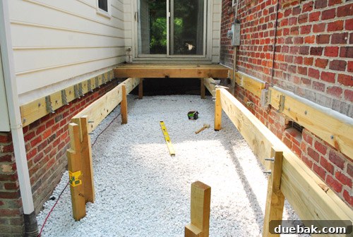 Working on securing joists with nails and hangers, a physically demanding task.