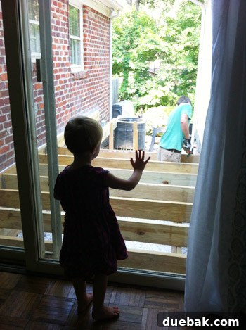 Clara, a young girl, watching her dad build the deck, showing interest in the project.