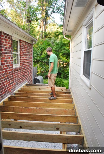 Person standing on the newly installed deck joists, testing its stability.