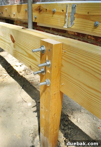 Close-up view of multiple through-bolts securing joined girder sections to a deck post.