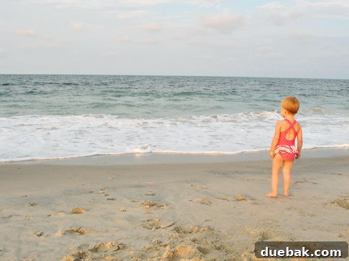Bethany Beach Bliss: A Delaware Getaway 27 Clara standing at the edge of the ocean on a beach, looking at the waves.