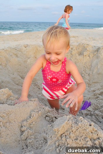 Bethany Beach Bliss: A Delaware Getaway 28 Clara and another young girl playing in a large sand hole on the beach.