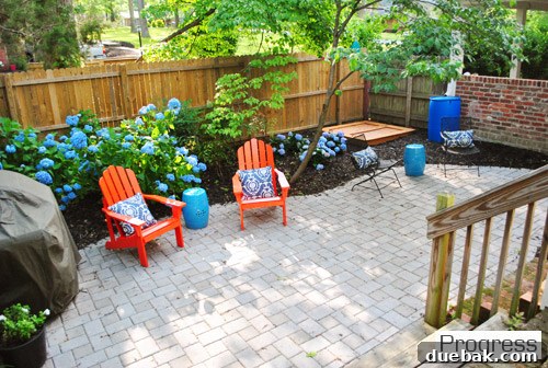Listy McListerson Refreshed 23 Our completed paver patio, featuring a custom curved edge, landscaped surroundings, and a rock box for children's play.
