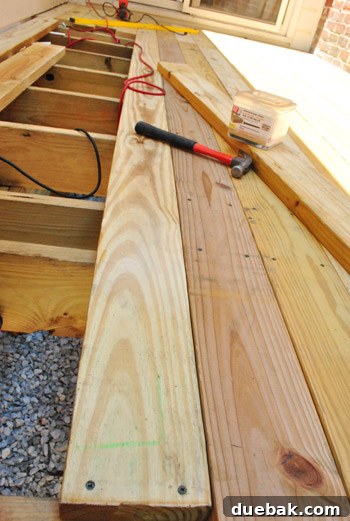 The Foundation of Your Deck 25 The author securing a straightened deck board with screws after forcing it into position.