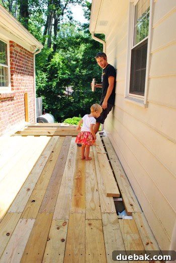 The Foundation of Your Deck 27 Clara intently examining the newly installed deck boards, seemingly inspecting the work.