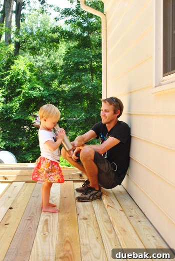 The Foundation of Your Deck 29 Clara reaching for her father's water bottle, seeking refreshment on the deck.