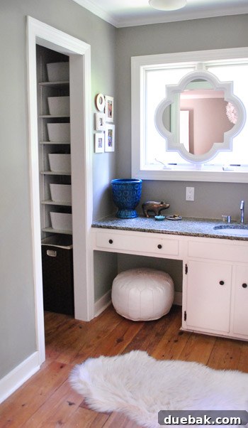 Close-up of the repurposed white Ikea bins in the closet, showing their clean, minimalist design when handles are turned inward.