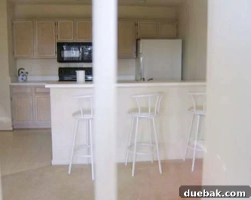 Before kitchen makeover with builder-grade finishes and outdated flooring