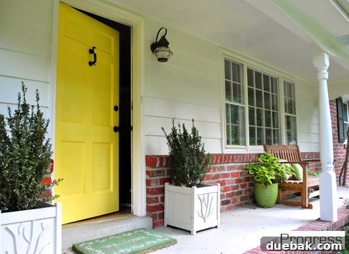 My First Home Then and Now: A Year's Perspective 5 Current house front porch, featuring a vibrant yellow door and simple decor.