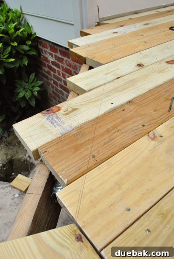 Crafting Your Perfect Outdoor Deck 11 Marking and cutting the angled piece with a saw.