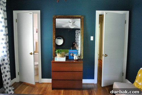 Mirroring Elegance Above the Mantel 3 A large mirror leaning against a dresser in a guest room, being considered for relocation.