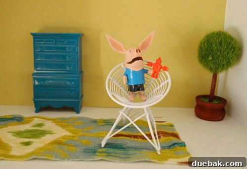 The Rise of the Egg Chair 3 Close-up of a miniature egg chair with a tiny doll character seated, showcasing its perfect fit.