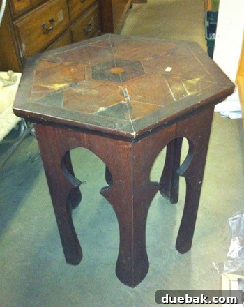 Close-up of a vintage Moroccan accent table with intricate carvings, before cleaning and restoration, showing signs of age and wear