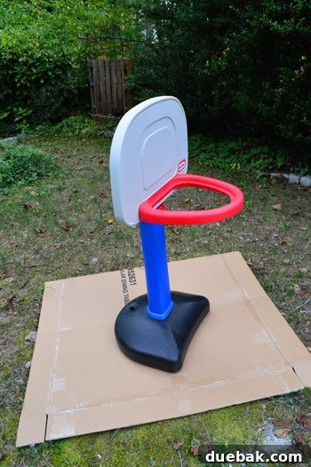 Basketball hoop disassembled in the backyard, ready for spray painting