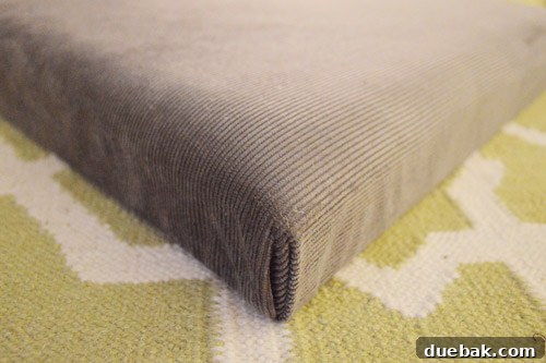 Detail of fabric being folded into a neat corner for upholstery