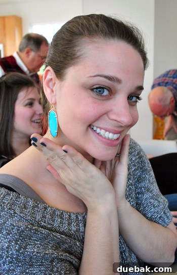 Woman smiling, showcasing large, colorful earrings