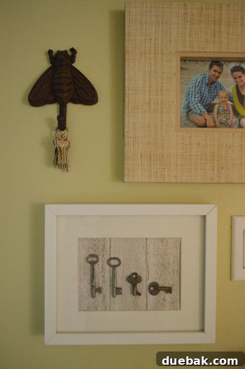 Finished framed antique key art with keys representing a family, displayed upright.