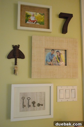 Framed antique key art hanging on a wall in a laundry room, next to a door.