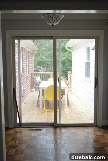 The old sliding door's exterior front view, showing its dated and worn appearance before replacement.