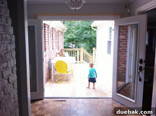 Newly installed French doors, primed white and awaiting their final coat of paint, showing fresh trim.