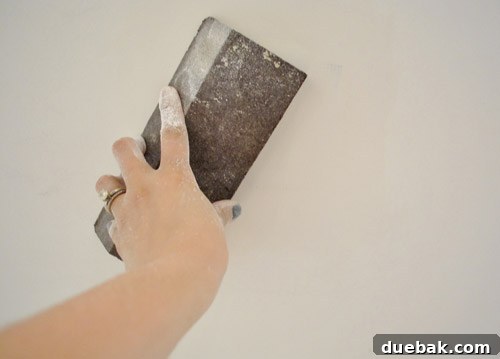 Close-up of a wall undergoing drywall repair, highlighting the importance of smooth spackle application