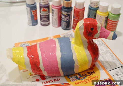 Wooden duck after first paint coat, looking messy