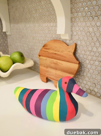 Finished painted wooden duck with colorful stripes in a kitchen setting