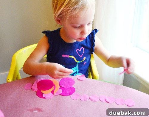 Three Playful Pumpkin Crafts for Little Ones 9 Clara playing with leftover tissue paper dots, sorting and lining them up