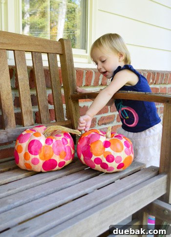 Three Playful Pumpkin Crafts for Little Ones 12 Clara, in her 'messy' shirt, next to the decorated pumpkins