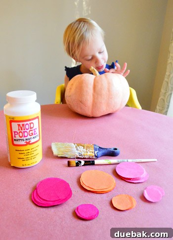 Three Playful Pumpkin Crafts for Little Ones 3 Craft materials laid out: tissue paper, Mod Podge, paintbrush, electrical tape