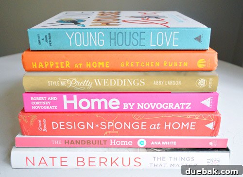 A curated collection of design, decor, and lifestyle books stacked neatly, featuring titles like 'The Things That Matter' and 'The Handbuilt Home'.
