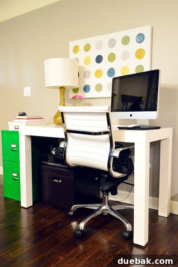 Stylish yellow glass lamp on a desk, complemented by abstract swirly canvas art