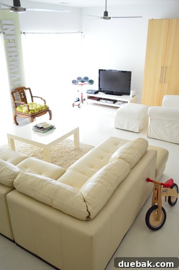 Roommates By Blood 15 Basement rec room with painted concrete floors and a large leather sectional